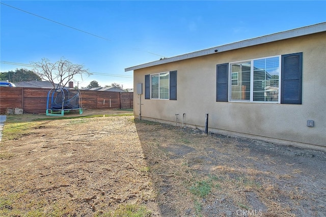 1261 W 13th St, San Bernardino, CA 92411 - view of side of home with stucco siding and a fenced backyard