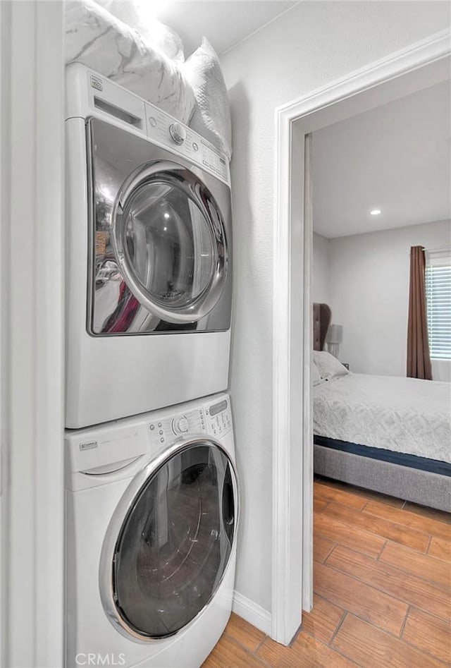 1261 W 13th St, San Bernardino, CA 92411 - clothes washing area with baseboards, laundry area, stacked washer / drying machine, and wood finished floors