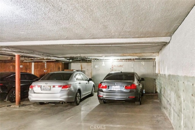 view of vehicle parking featuring a parking garage