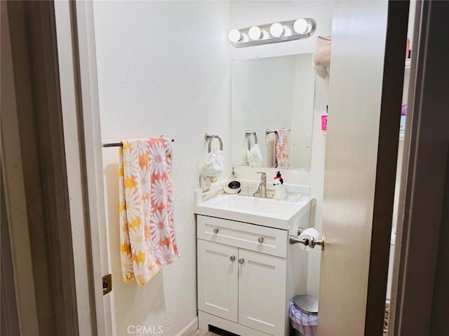 bathroom with vanity and a textured wall