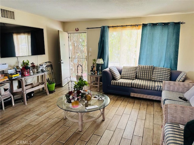 living area featuring light wood-type flooring and visible vents