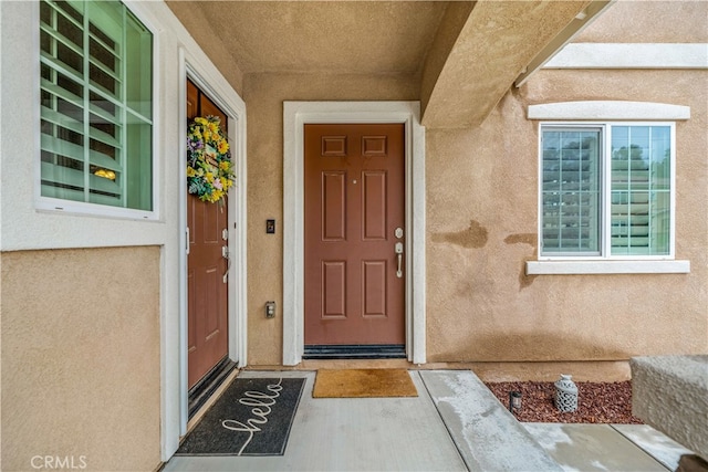 entrance to property featuring stucco siding