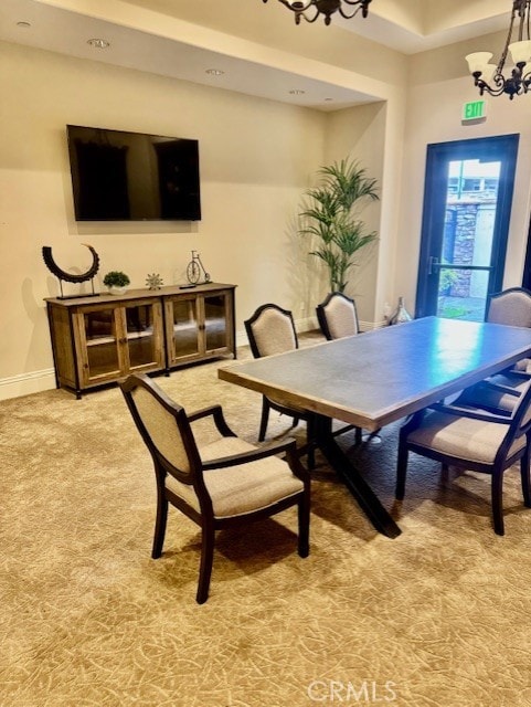 dining space with baseboards, an inviting chandelier, and light colored carpet