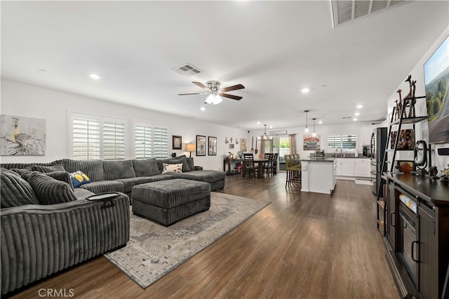 living room featuring visible vents, a ceiling fan, dark wood-type flooring, and recessed lighting