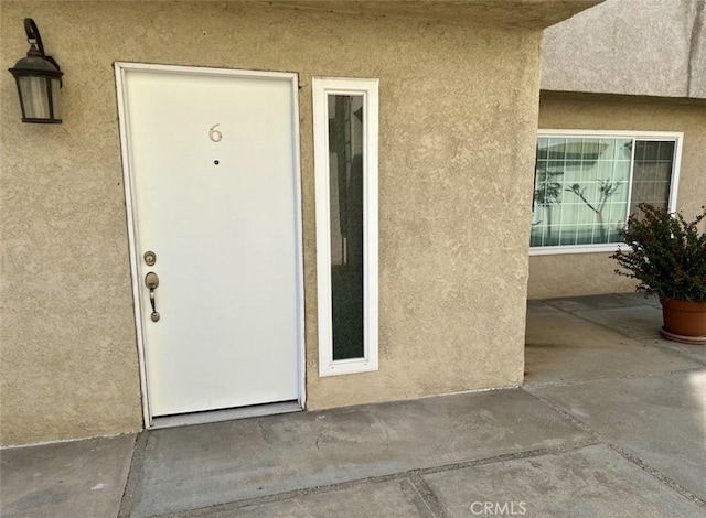 doorway to property featuring stucco siding