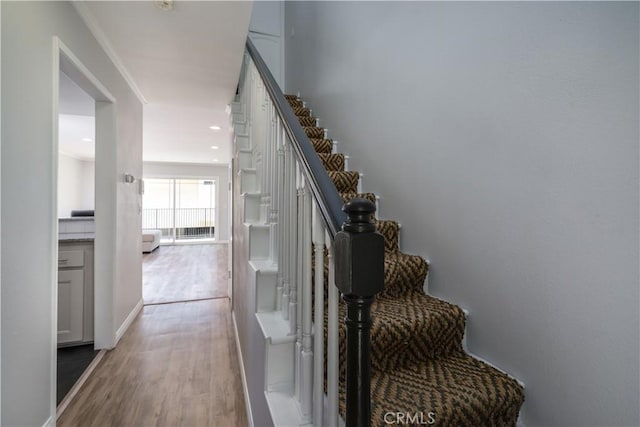 stairway with baseboards, recessed lighting, and wood finished floors