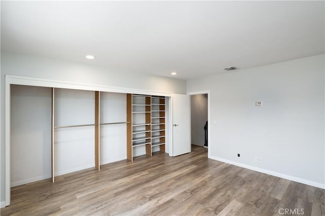 unfurnished bedroom featuring wood finished floors, baseboards, and recessed lighting