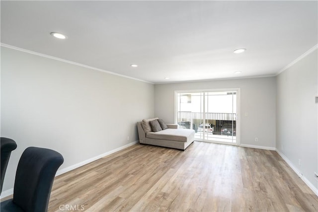 living area featuring ornamental molding, light wood-style flooring, and baseboards