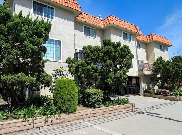 exterior space featuring stucco siding and a tiled roof