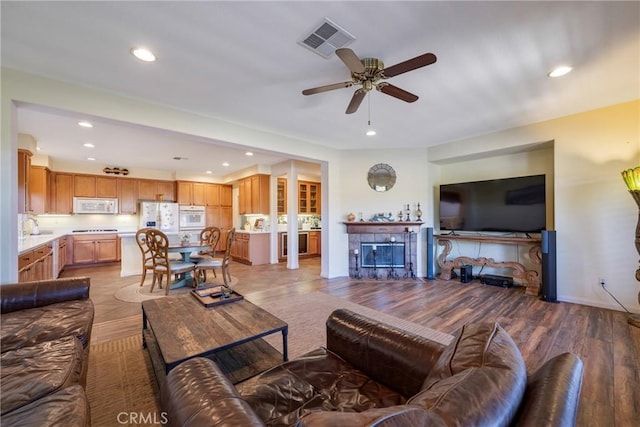 38493 Falkirk Dr, Murrieta, CA 92563 - living room with recessed lighting, ceiling fan, light wood-style floors, a fireplace, and baseboards