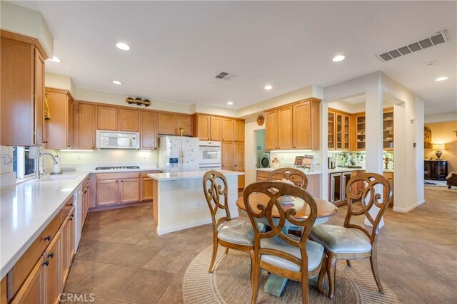 38493 Falkirk Dr, Murrieta, CA 92563 - kitchen with white appliances, light countertops, recessed lighting, light tile patterned floors, and a kitchen island