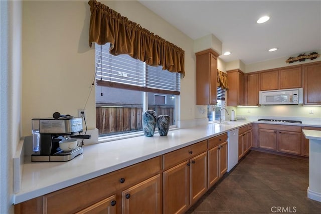38493 Falkirk Dr, Murrieta, CA 92563 - kitchen with white appliances, light countertops, a sink, dark tile patterned flooring, and brown cabinetry