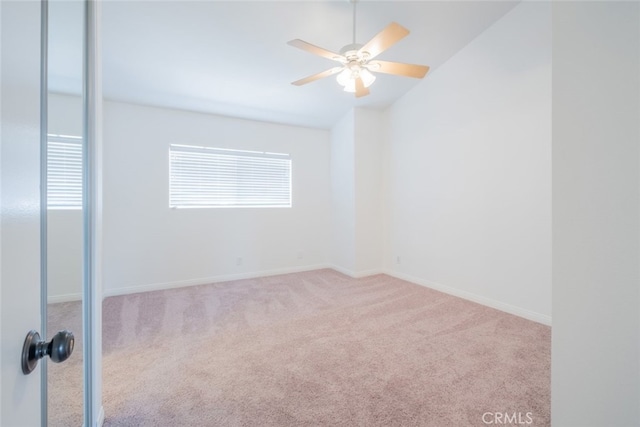 unfurnished room featuring carpet, a ceiling fan, baseboards, and lofted ceiling