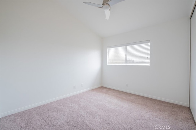unfurnished room featuring light colored carpet, lofted ceiling, baseboards, and a ceiling fan
