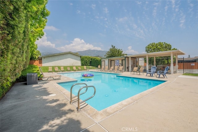 community pool with a patio and fence