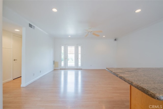 unfurnished living room featuring ornamental molding, visible vents, ceiling fan, light wood-style flooring, and baseboards