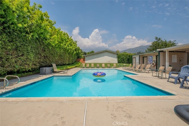 community pool with a patio area and a mountain view