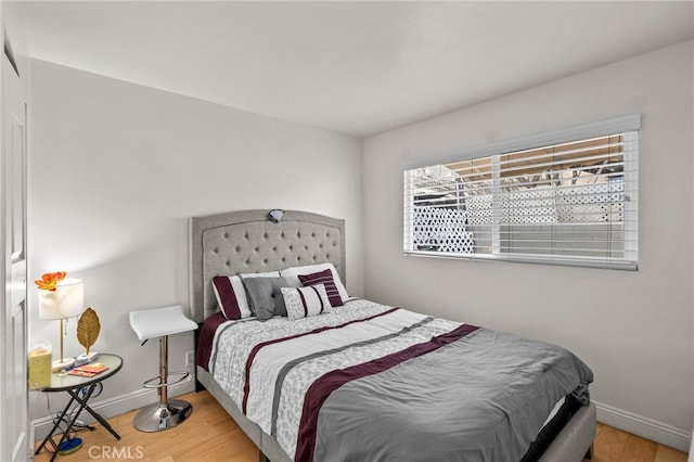 bedroom featuring baseboards and wood finished floors