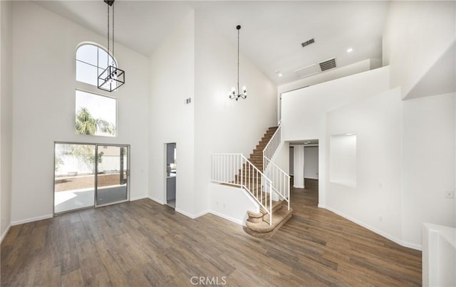 entryway with a healthy amount of sunlight, an inviting chandelier, high vaulted ceiling, and visible vents