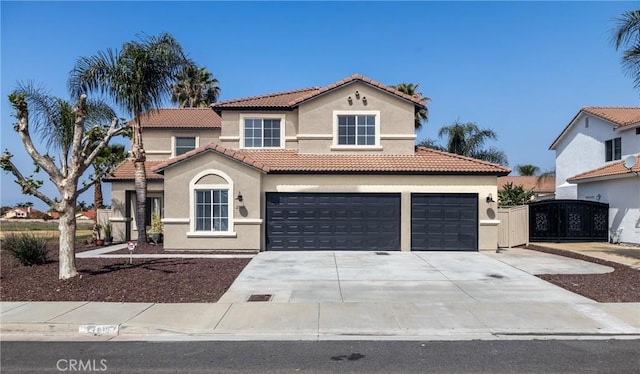 mediterranean / spanish-style house with concrete driveway, stucco siding, a tile roof, and an attached garage