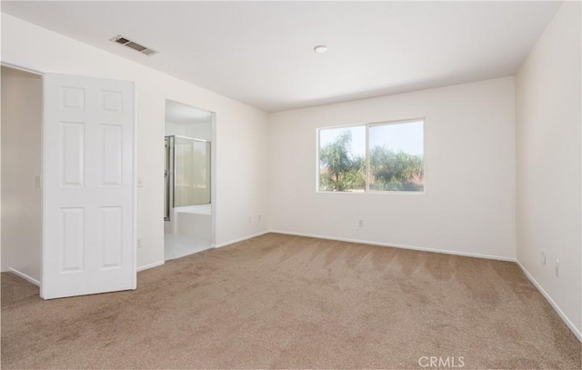 unfurnished bedroom with connected bathroom, carpet floors, baseboards, and visible vents