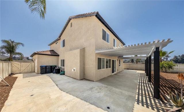 back of property featuring stucco siding, a pergola, a fenced backyard, and a patio