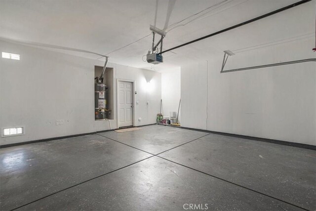 13167 Hollister St, Hesperia, CA 92344 - garage with a garage door opener, water heater, and baseboards