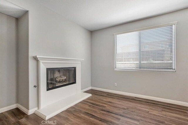 13167 Hollister St, Hesperia, CA 92344 - unfurnished living room featuring wood finished floors, baseboards, and a glass covered fireplace