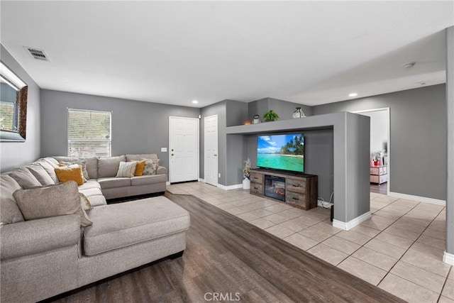 living room with baseboards, light tile patterned floors, visible vents, and recessed lighting