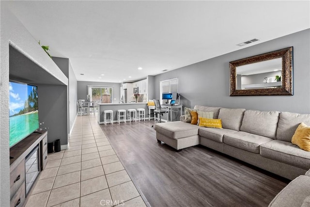 living room featuring light tile patterned floors, visible vents, and recessed lighting