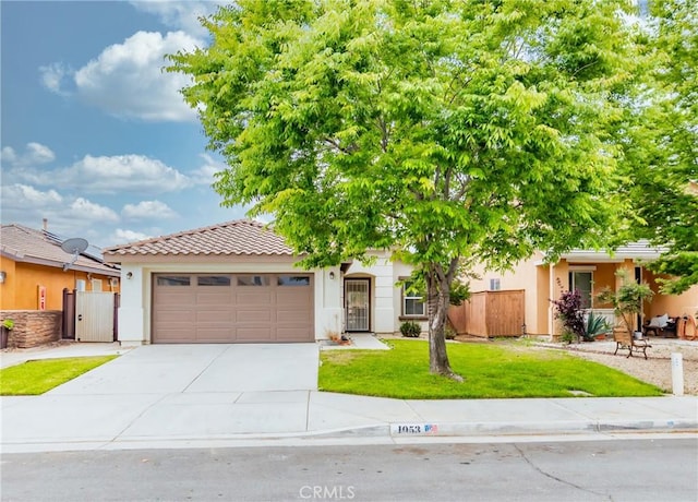 view of front of home with fence, an attached garage, concrete driveway, stucco siding, and a front lawn
