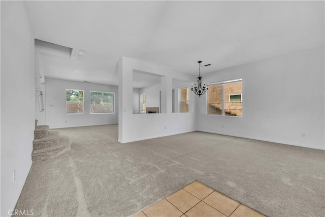 43629 Rucker Ct, Lancaster, CA 93535 - unfurnished living room featuring baseboards, carpet flooring, tile patterned flooring, a chandelier, and stairway