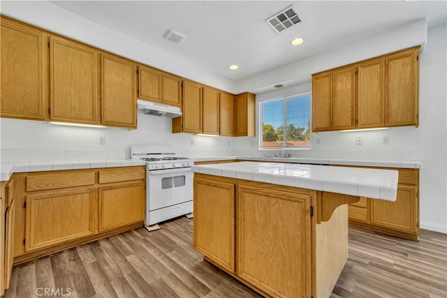 43629 Rucker Ct, Lancaster, CA 93535 - kitchen featuring light wood-type flooring, white range with gas cooktop, visible vents, and under cabinet range hood
