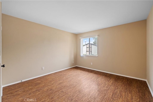empty room featuring baseboards and wood finished floors