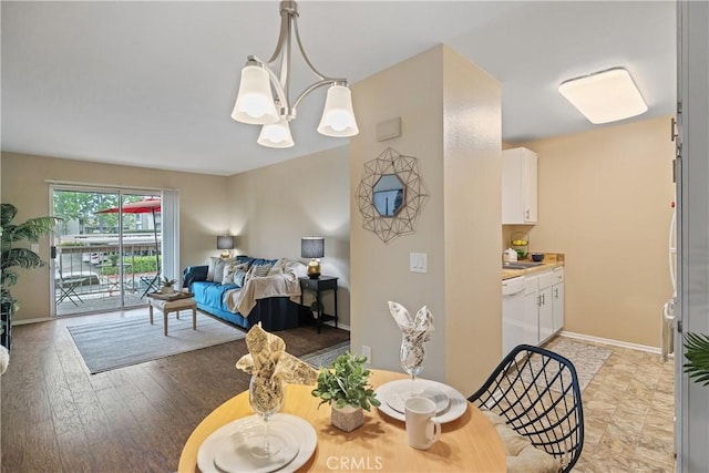 dining room featuring an inviting chandelier, light wood-style floors, and baseboards