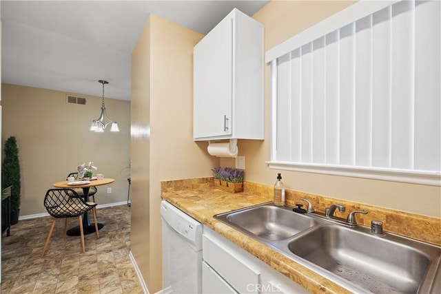 kitchen with a sink, visible vents, white cabinetry, light countertops, and white dishwasher