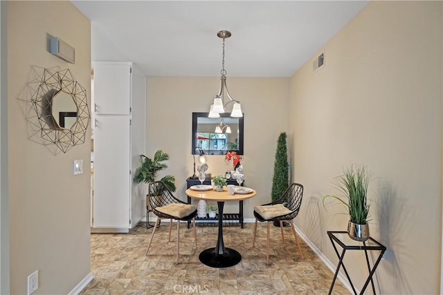 dining room featuring baseboards, stone finish floor, and visible vents