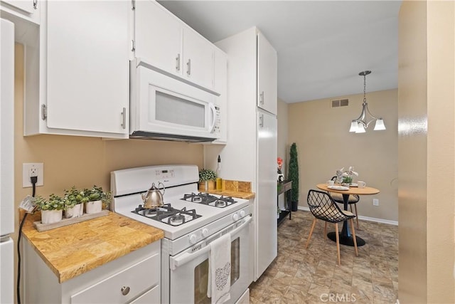 kitchen with hanging light fixtures, white cabinets, visible vents, white appliances, and light countertops