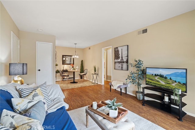 living room with visible vents, wood finished floors, and baseboards