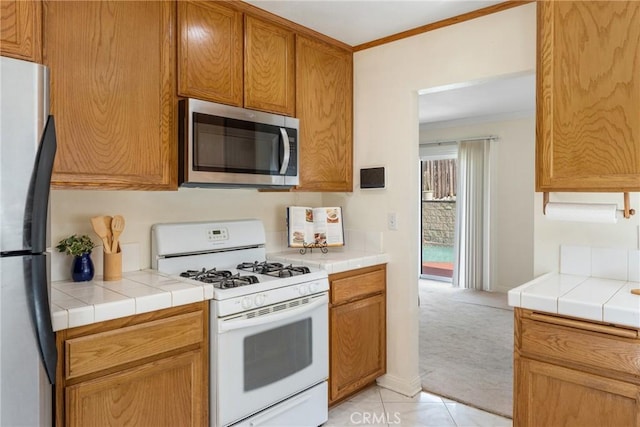 35230 San Carlos St, Yucaipa, CA 92399 - kitchen with light colored carpet, crown molding, appliances with stainless steel finishes, and tile counters