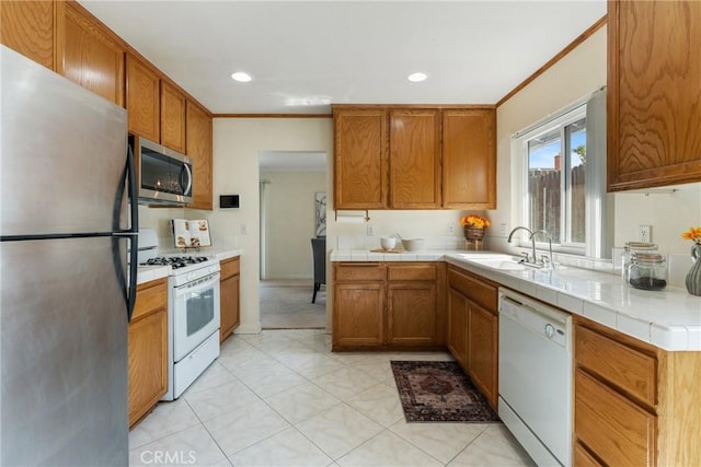 35230 San Carlos St, Yucaipa, CA 92399 - kitchen featuring a sink, brown cabinets, crown molding, tile counters, and appliances with stainless steel finishes