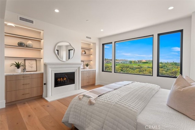 4 Sunset Cv, Newport Coast, CA 92657 - bedroom with visible vents, a lit fireplace, light wood-style flooring, and recessed lighting