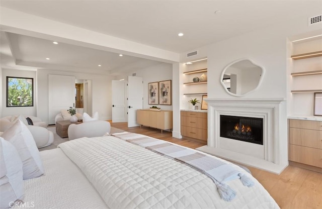 4 Sunset Cv, Newport Coast, CA 92657 - bedroom featuring recessed lighting, light wood-style floors, visible vents, and a lit fireplace