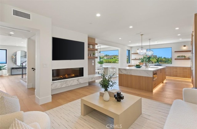 4 Sunset Cv, Newport Coast, CA 92657 - living room with a premium fireplace, recessed lighting, a wealth of natural light, and light wood-style floors
