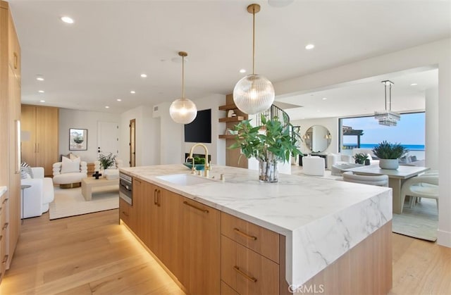 4 Sunset Cv, Newport Coast, CA 92657 - kitchen with a sink, open floor plan, light wood-type flooring, modern cabinets, and a large island