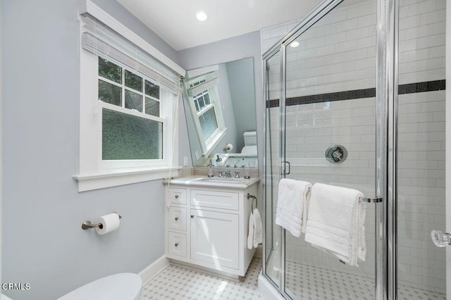full bathroom featuring toilet, vanity, tile patterned floors, a shower stall, and baseboards