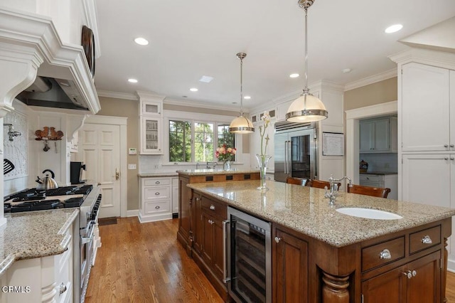 kitchen with a large island, high quality appliances, a sink, and beverage cooler