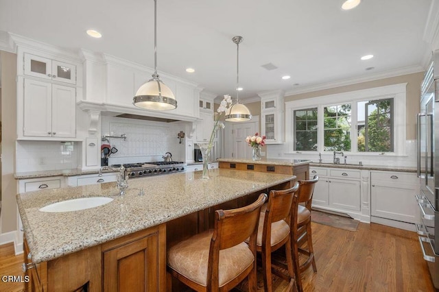 kitchen featuring white cabinetry and an island with sink