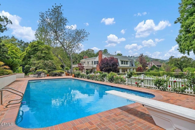outdoor pool featuring fence and a patio area