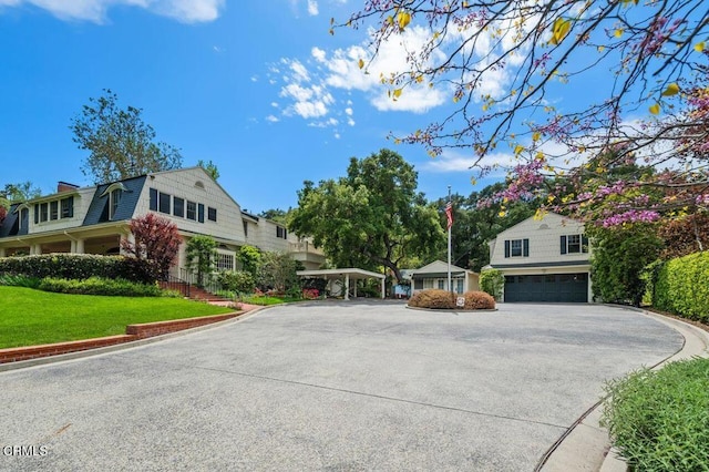 view of front of home featuring an attached garage, driveway, and a front yard